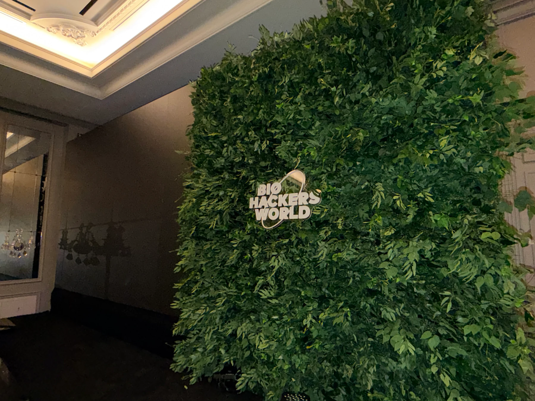 Greenery wall with illuminated Biohackers World signage