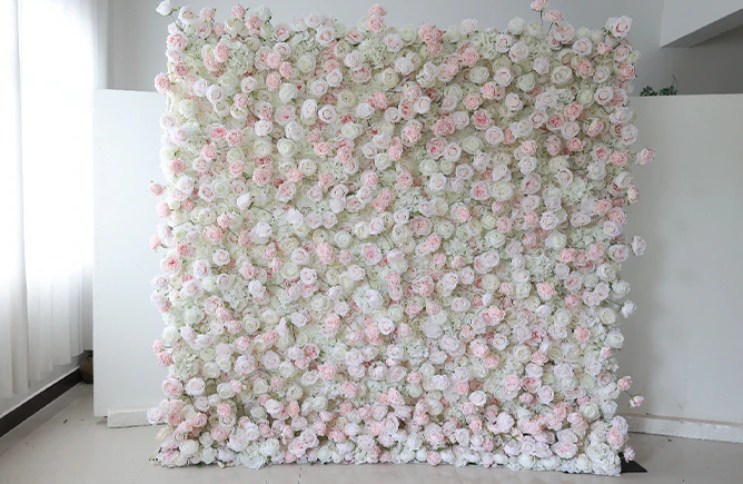 Blush and ivory rose flower wall installed against a wall in a New York venue
