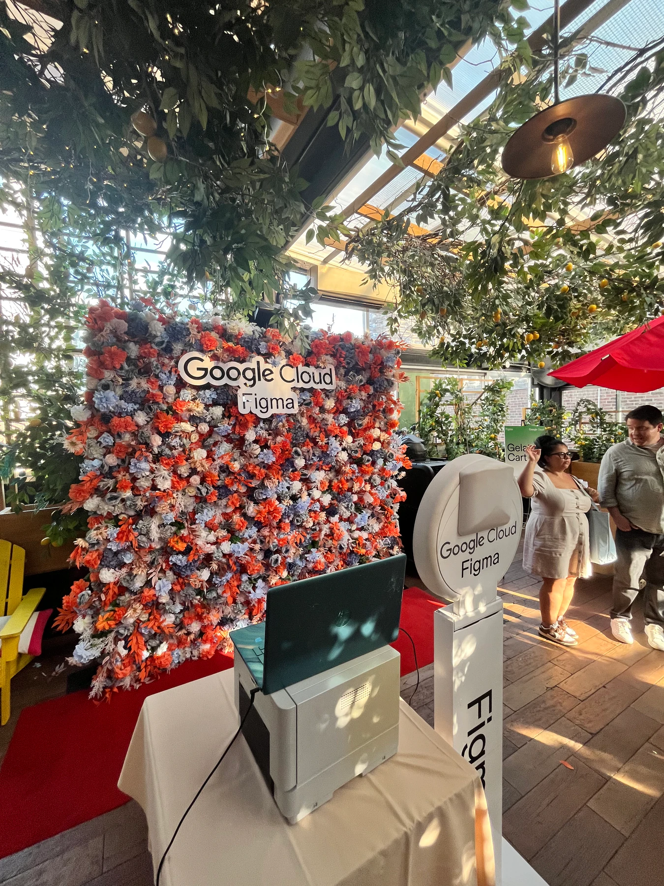 Photo booth beside a branded flower wall at a Google Cloud and Figma event in New York