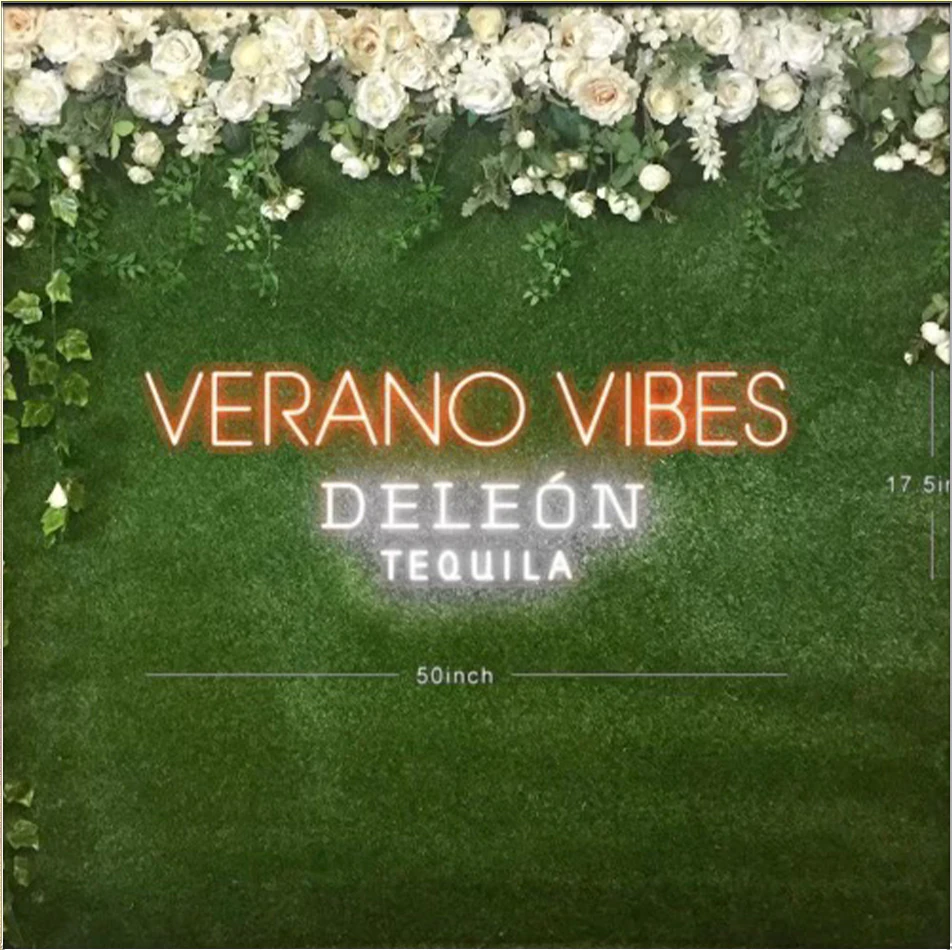 Custom neon signage produced for a New York event, mounted against a floral backdrop