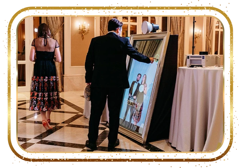 Mirror photo booth set up beside a floral backdrop at a New York City event